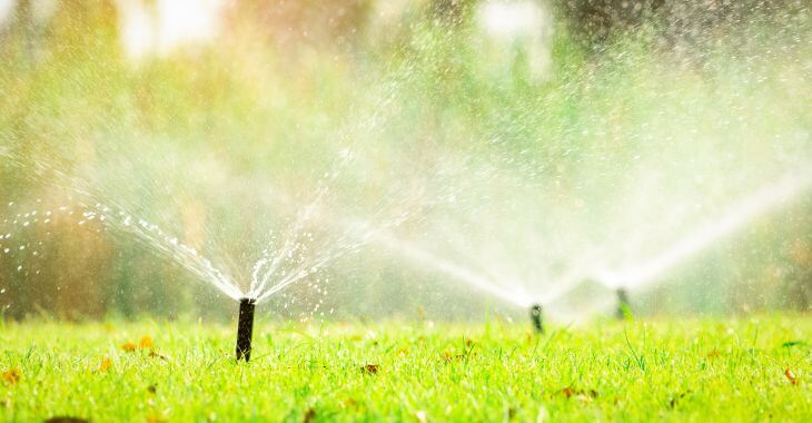 Working sprinkler system watering autumn lawn.