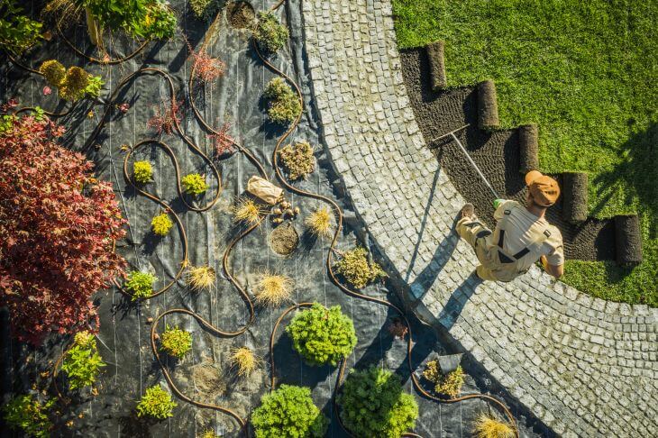 A professional landscaper applying topsoil after calculating how many yards of topsoil he needs