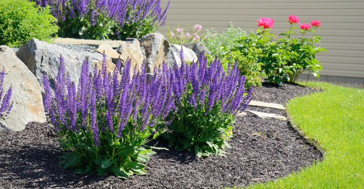 A front yard with decorative rocks used for retaining walls.