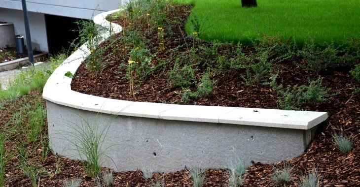 Retaining wall supporting soil from falling down on the walkway.