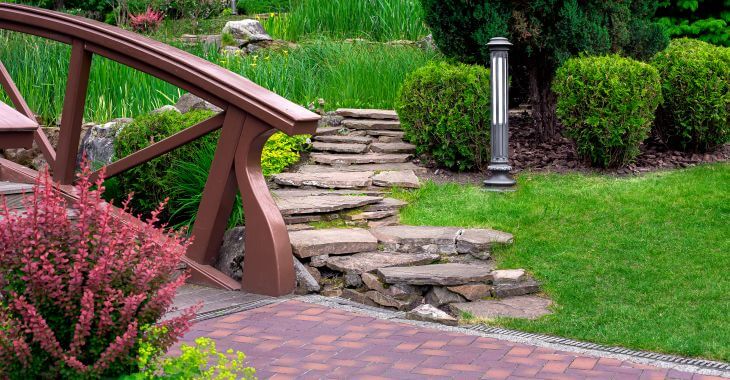 Beautiful garden with a pond, hardscapes and French drain along the paver.