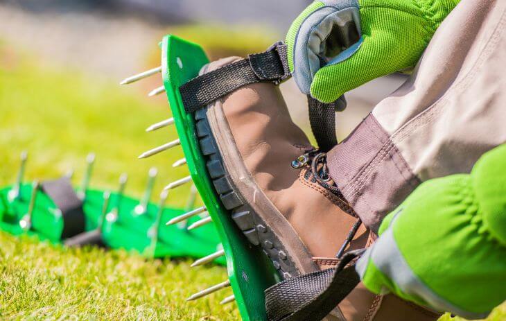 A man putting on special spike shoes for lawn areation