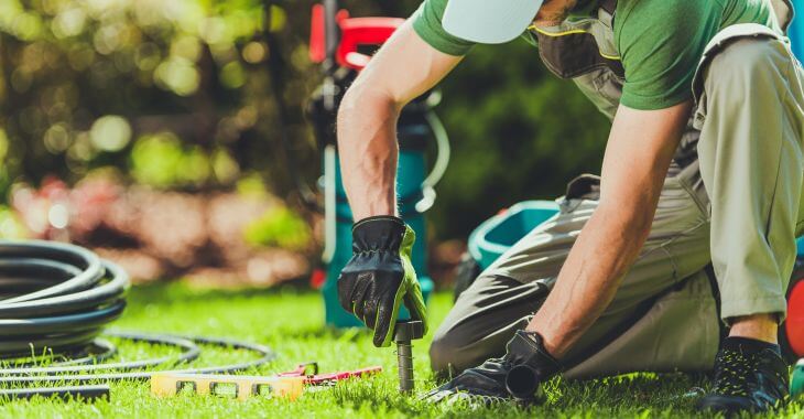 a professional technician performing sprinkle system audit and maintenance